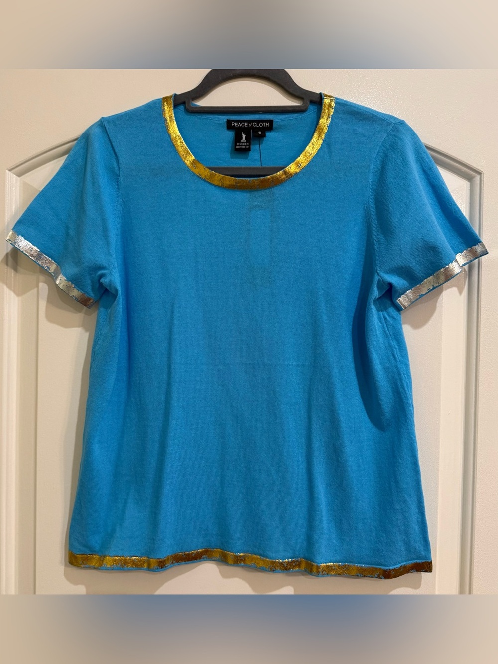 Peace of Cloth pullover shirt.  Blue with gold and silver trim. Size small.